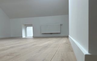 appartement avec plancher clair et murs blancs