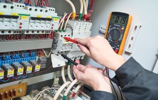 électricien qui travaille sur un tableau électrique